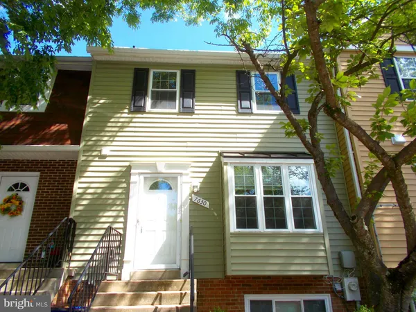a view of a house with a door and a large tree