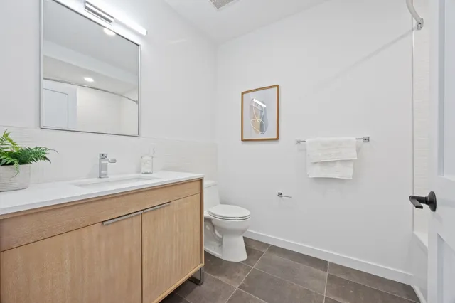 a bathroom with a toilet sink and mirror