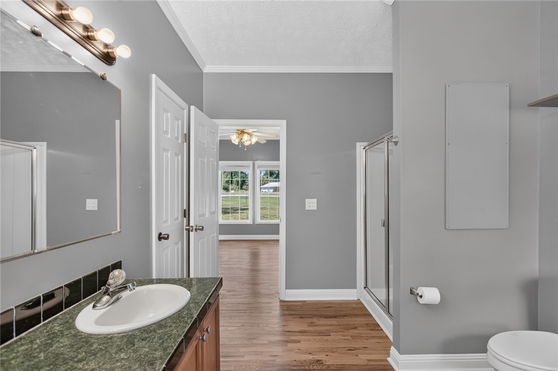 564 Fairfield Road Walhalla, SC 29691 - Photo 21 of 50 Smooth wood floors and crisp trim connect the vanity area to a walk-in shower.