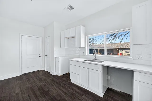 a kitchen with a sink cabinets and wooden floor