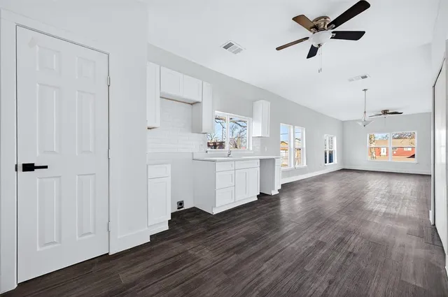 a view of a kitchen with refrigerator and wooden floor
