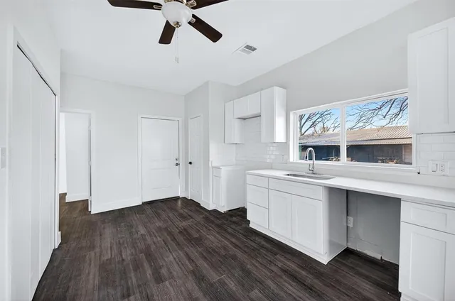 a kitchen with cabinets wooden floor and stainless steel appliances