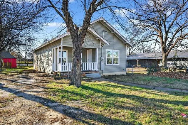 a view of a house with backyard and trees