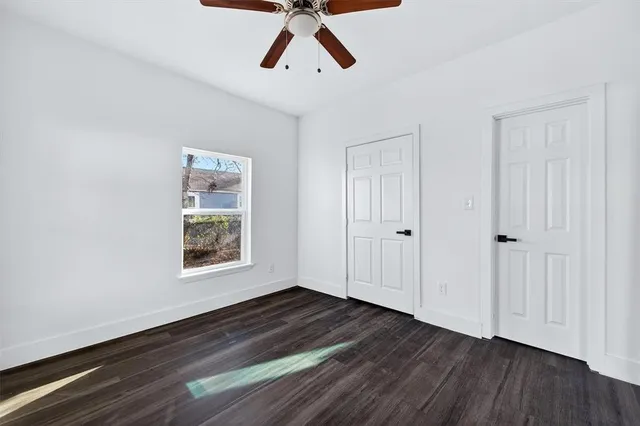 a view of empty room with wooden floor and window