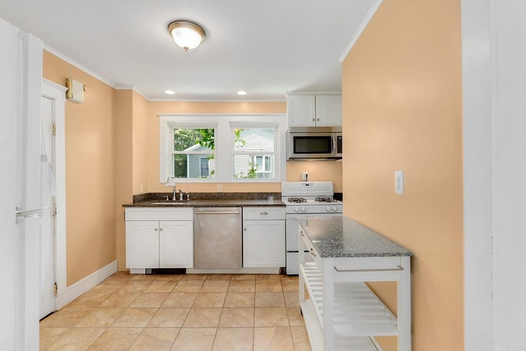 79 Ripley Street, Unit 79 Newton, MA 02459 - Photo 3 of 18 a kitchen with stainless steel appliances granite countertop a stove a sink and a refrigerator