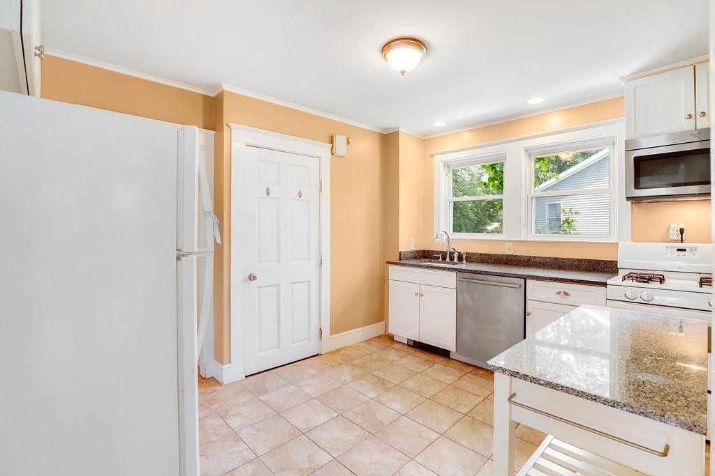 79 Ripley Street, Unit 79 Newton, MA 02459 - Photo 4 of 18 a kitchen with stainless steel appliances granite countertop a sink and a stove