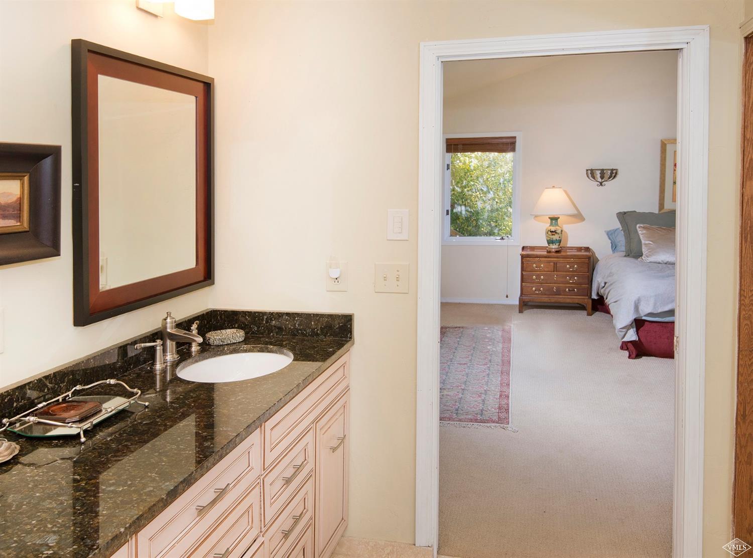 972 Eagle Drive Avon, CO 81620 - Photo 20 of 25 a en suite bathroom with a granite countertop sink and a mirror