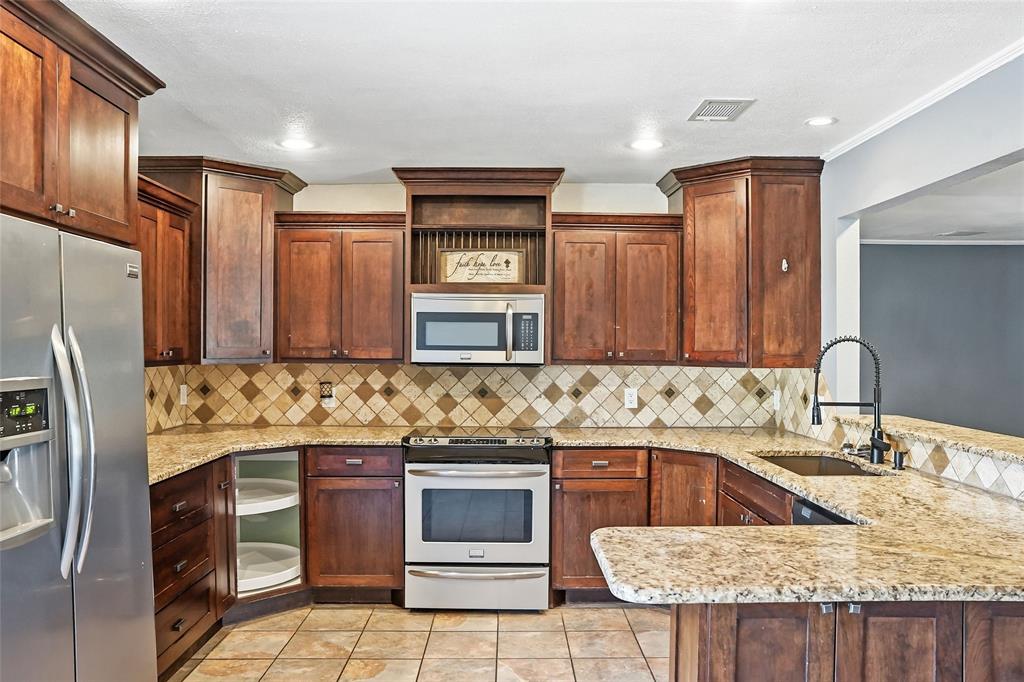 1325 Carter Street Sulphur Springs, TX 75482 - Photo 13 of 31 a kitchen with stainless steel appliances granite countertop a sink stove and refrigerator