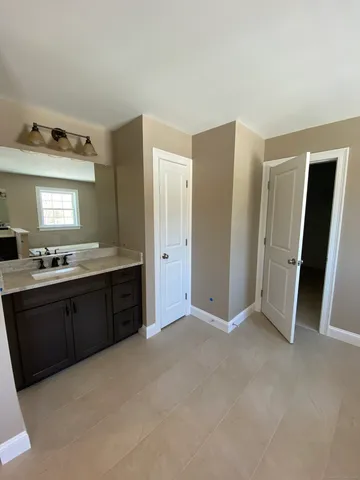a large bathroom with a granite countertop sink and a mirror