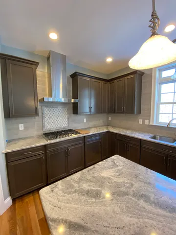 a kitchen with granite countertop a sink cabinets and stainless steel appliances