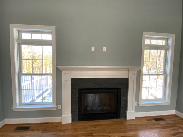 a view of an empty room with a fireplace and a window