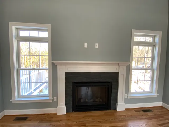 a view of an empty room with a fireplace and a window