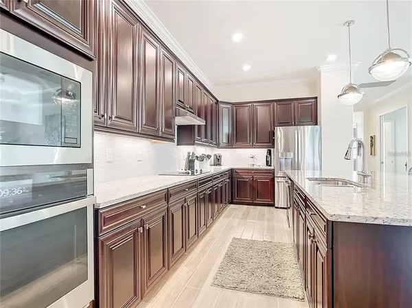 a kitchen with kitchen island granite countertop a sink stove and cabinets