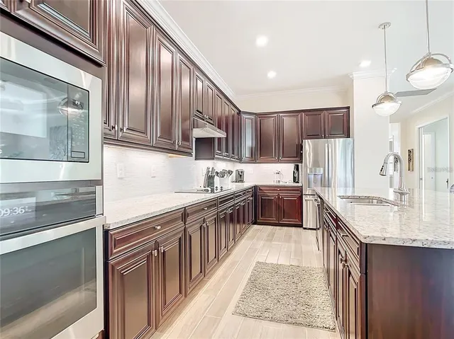 a kitchen with kitchen island granite countertop a sink stove and cabinets