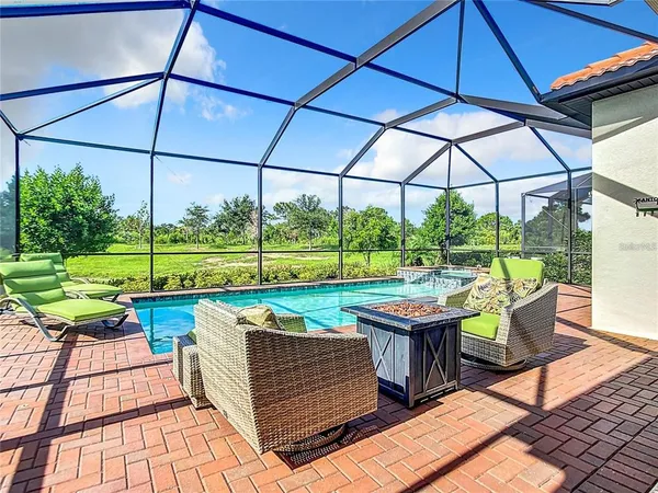 a view of swimming pool with a yard and palm trees