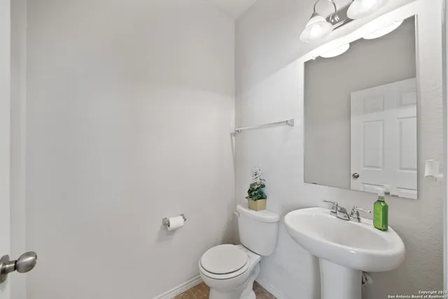 a bathroom with a sink a toilet and a mirror