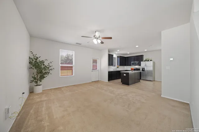 a large white kitchen with a large window and stainless steel appliances
