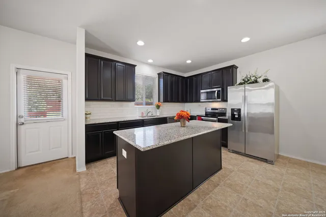 a kitchen with kitchen island a counter top space cabinets and stainless steel appliances