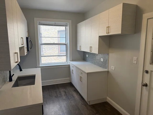a kitchen with a sink a window and cabinets