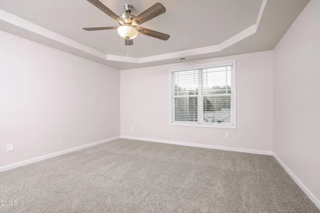 an empty room with a window and a fan
