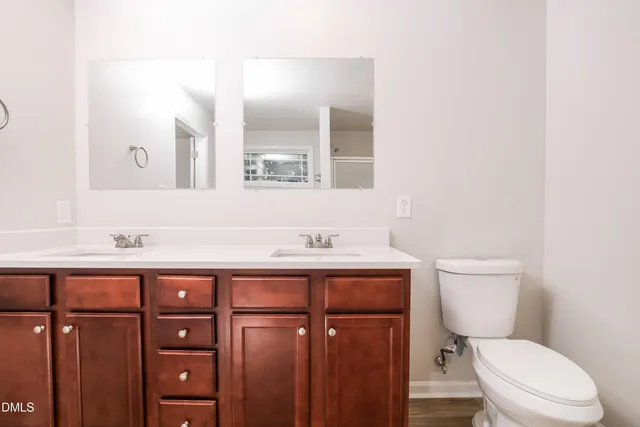 a bathroom with a granite countertop toilet sink and mirror
