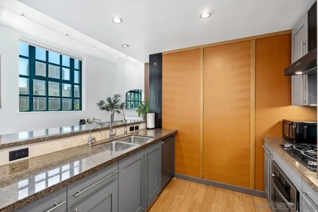 a kitchen with granite countertop a sink and a refrigerator