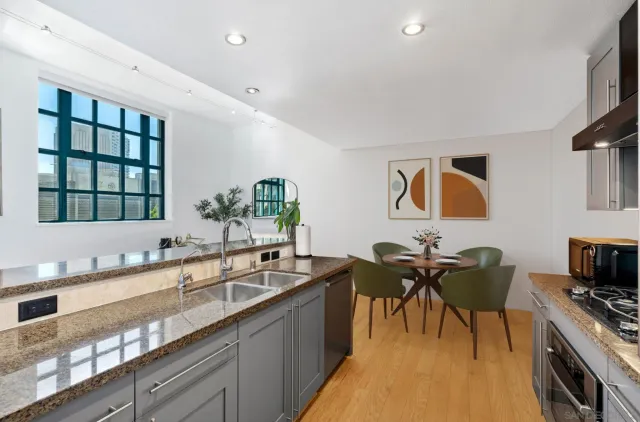 a kitchen with granite countertop a sink and a stove top oven with wooden floor