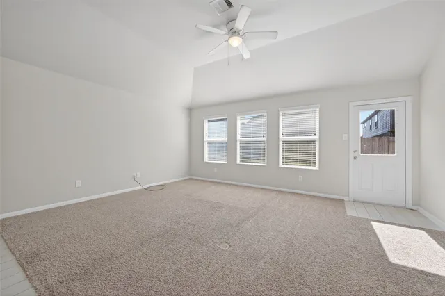 an empty room with windows and ceiling fan