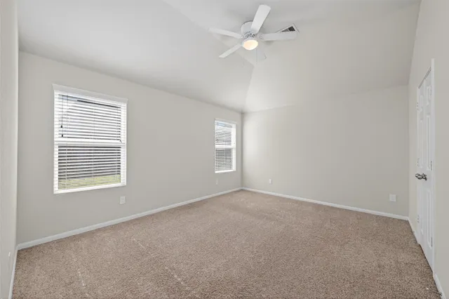 an empty room with a window and ceiling fan