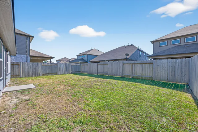 a view of a backyard with table and chairs with wooden fence