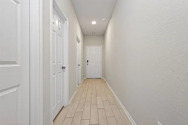 a view of a hallway with wooden floor