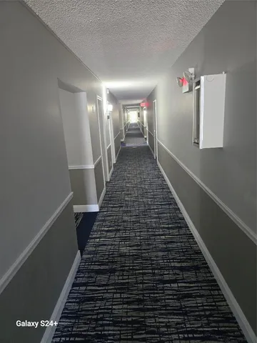 a view of a hallway with wooden floor and stairs