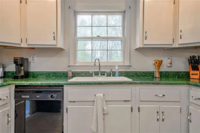a kitchen with granite countertop white cabinets and white appliances