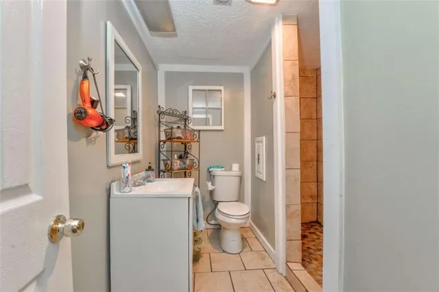 an empty room with chandelier fan and windows