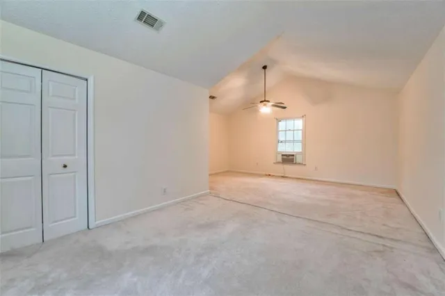 a backyard of a house with large trees and covered with wooden fence