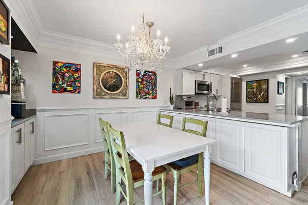 a kitchen with kitchen island granite countertop a wooden floor and white cabinets