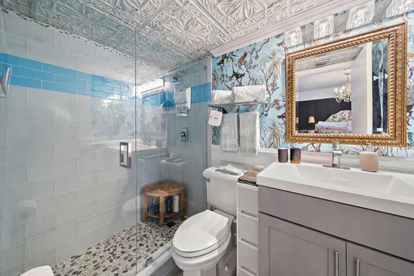 a bathroom with a sink toilet vanity and shower