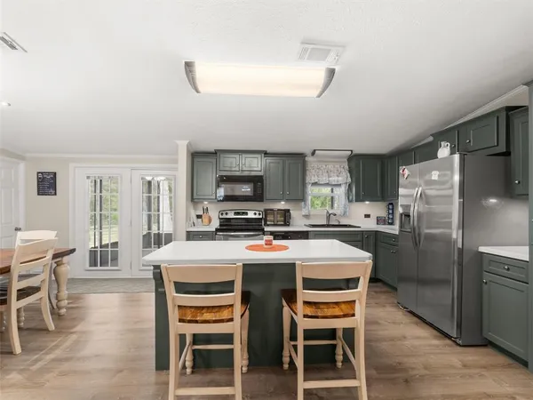 a kitchen with a table chairs refrigerator and cabinets