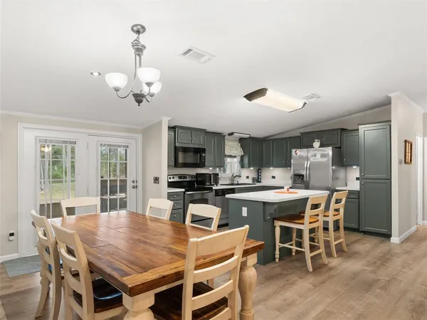 a dining room with a table chairs and kitchen view