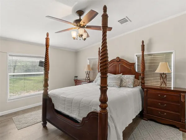 a bedroom with a bed a chandelier and a window