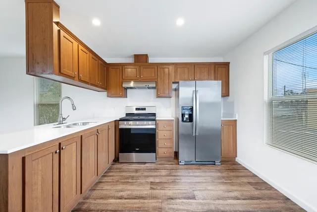 a kitchen with stainless steel appliances granite countertop a refrigerator and a stove