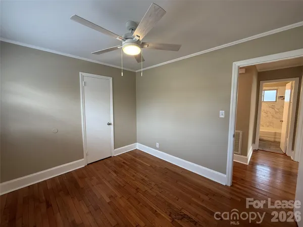 a view of an empty room with wooden floor