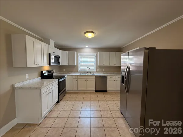 a kitchen with stainless steel appliances granite countertop a refrigerator sink and cabinets