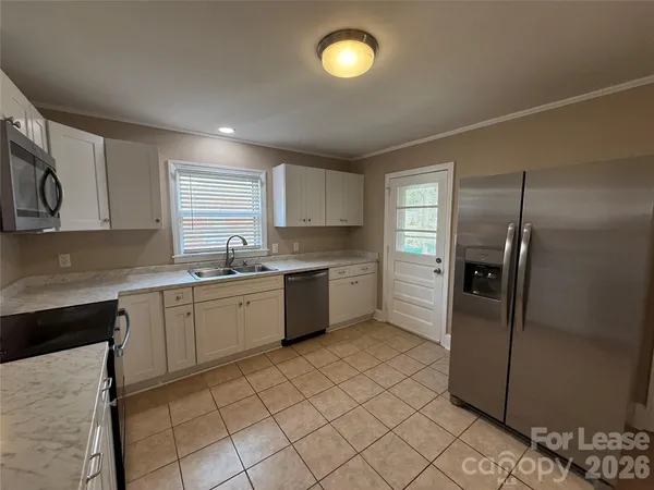 a kitchen with a sink a refrigerator and cabinets
