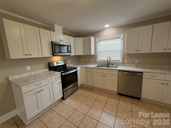 a kitchen with a sink stove top oven and cabinets