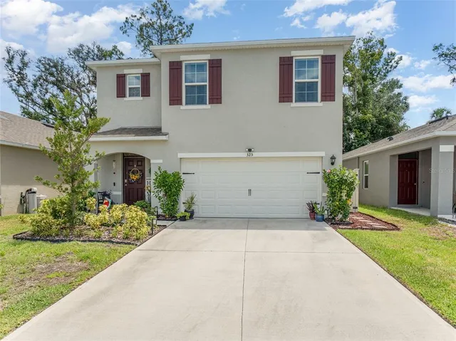 a front view of a house with a yard and garage