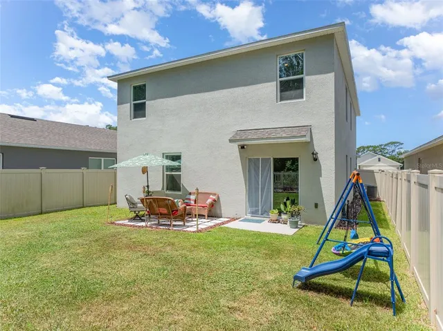 a view of a house with a backyard and a slide