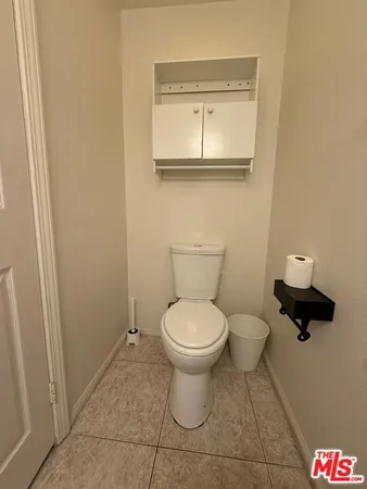 a white toilet sitting next to a white sink and vanity