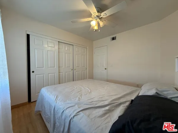 a bedroom with a bed and a ceiling fan