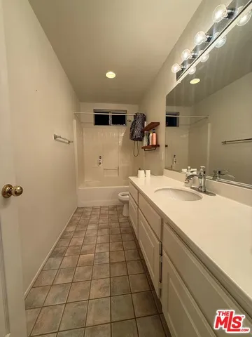 a spacious bathroom with a sink a mirror and a shower